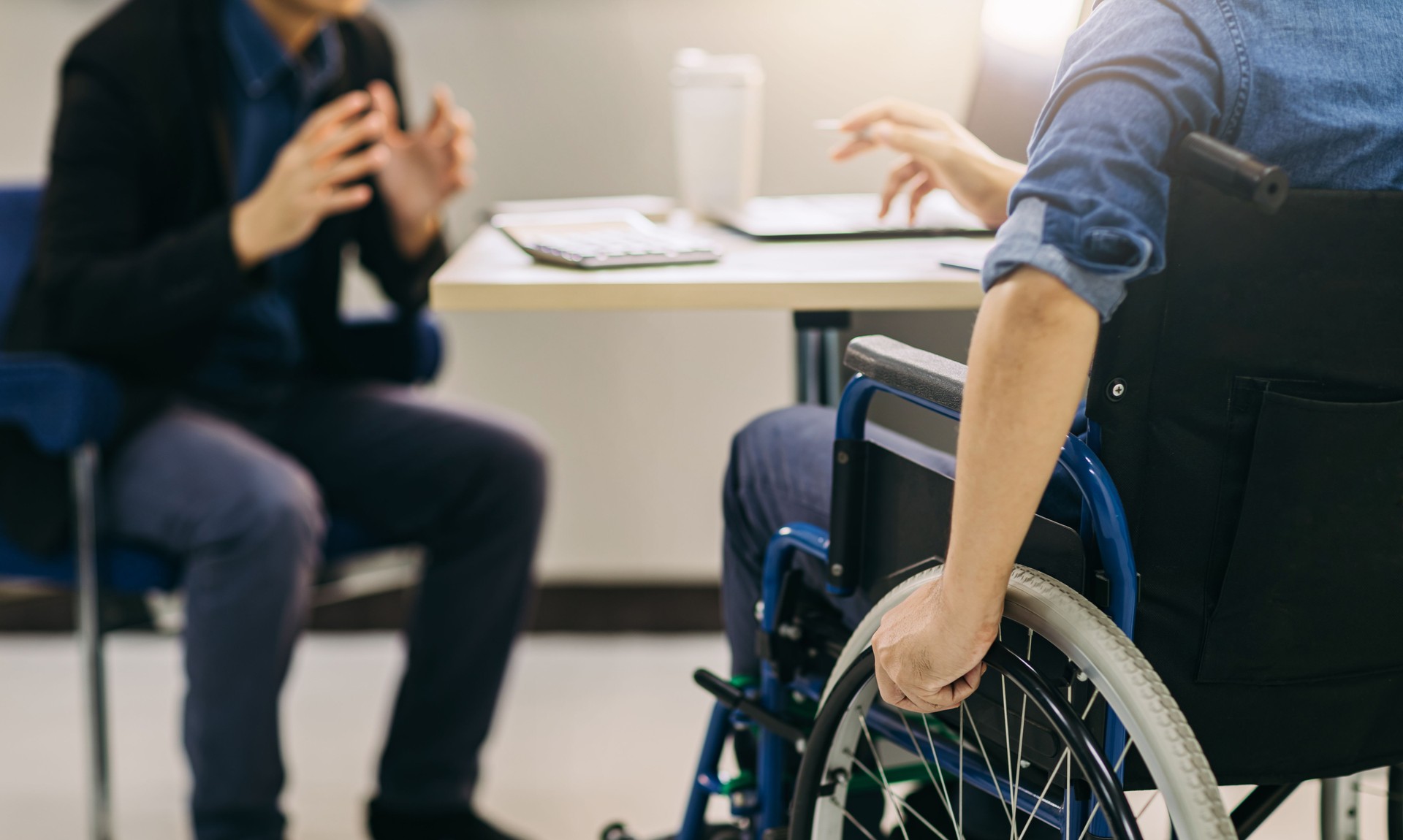 After accident and rehabilitation, a disabled man can return to work with wheelchair. Company which job hiring employing disabilities people will receive tax deductions benefits.